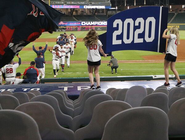 Cutout fans and two cheerleaders holding the 2020 pennant are the only ones looking on as the Atlanta Braves celebrate clinching their third consecutive National League East championship title Tuesday, Sept. 22, 2020, at Truits Park in Atlanta. (Curtis Compton / Curtis.Compton@ajc.com)