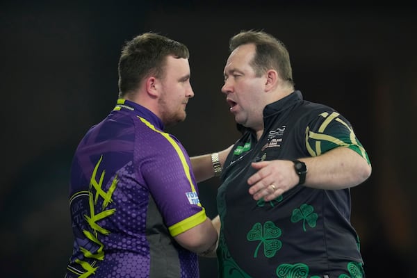 FILE - Luke Littler of England, left, shakes hands with Brendan Dolan of Northern Ireland after winning the quarterfinal match at the World Darts Championship, in London, Monday, Jan. 1, 2024. (AP Photo/Kin Cheung, File)