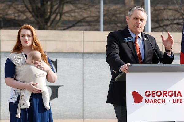 Rep. Lauren Daniel, R-Locust Grove, holds her baby Zane as Sen. Ed Setzler, R-Acworth, speaks during an  anti-abortion rally in February. Setzler, sponsor of the legislation that became Georgia’s abortion law, disagrees with medical professionals who said the statute is vague in terms of exceptions that would allow the procedure. Natrice Miller / natrice.miller@ajc.com