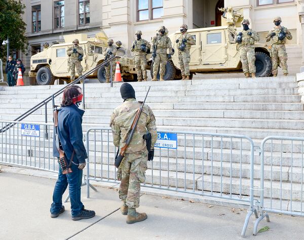 Two armed men address the Georgia National Guard soldiers and Georgia State Patrol officers stationed at the state Capitol Sunday, January 17, 2021, in Atlanta. (Photo: Daniel Varnado for The Atlanta Journal-Constitution)