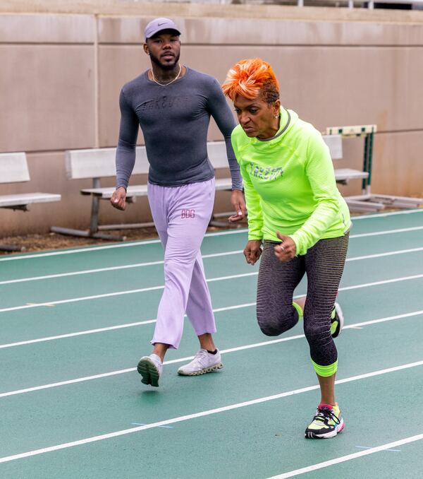 Sprinter India Bridgette (right) runs past her coach, Dantwan Spreads of TakeOff Track Club, as he watches her form during practice at the Westminster Schools track. PHIL SKINNER FOR THE ATLANTA JOURNAL-CONSTITUTION