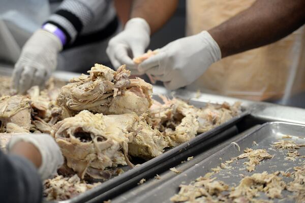 On Wednesday, nearly 100 volunteers prepared a traditional meal of turkey, sweet potatoes, stuffing and vegetables for distribution on Thanksgiving Day. KENT D. JOHNSON/ AJC