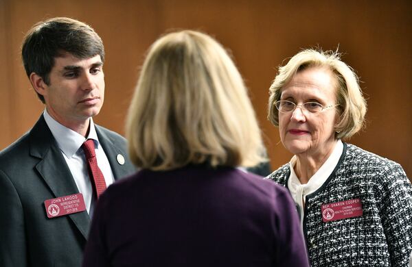 Reps. John LaHood (left) and Sharon Cooper talk to Peggy Lavender (foreground) before a news conference Thursday to unveil proposed reforms for senior care homes. At the conference, Lavender described her husband’s ordeal at an assisted living community. (Hyosub Shin / Hyosub.Shin@ajc.com)