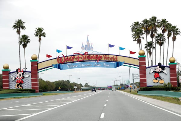 FILE - In this Monday, March 16, 2020, file photo, the road to the entrance of Walt Disney World has few cars, in Lake Buena Vista, Fla. Two more unions have reached agreements with Walt Disney World over furloughs caused by the theme park resort's closure during the new coronavirus outbreak. The agreements reached late Friday, April 10, apply to security guards and workers involved in facilities and operations. (AP Photo/John Raoux, File)