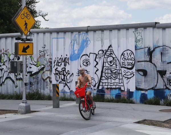 May 6, 2019 - Atlanta - A bicycle rider turns south onto the Atlanta Beltline eastside trail in front of the graffiti filled fence that borders the CSX yard. CSX is shifting international freight operations out of a massive switching station known as Hulsey Yard that bisects the Atlanta Beltline’s eastside trail. The site, which stretches some 40 to 70 acres along DeKalb Avenue east of downtown Atlanta, could be a lucrative redevelopment site. Eliminating the rail yard — the east-west tracks would remain active — also could help advance transit along the Beltline and become one of the premiere development locations in the city. Bob Andres / bandres@ajc.com