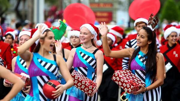 Members of the Seminole Ridge High School Hawk Marching Band wave to the crowd during the Wellington holiday parade along Forest Hill Boulevard. (Richard Graulich / The Palm Beach Post)