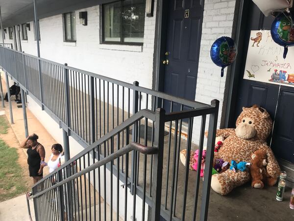 Stuffed animals, balloons and candles in front of the apartment of Lamora Williams and her children.