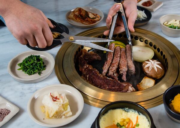 Servers at Ari Korean Steakhouse use kitchen shears to cut up large pieces of meat on the grill, making it easier to eat and share. CONTRIBUTED BY HENRI HOLLIS