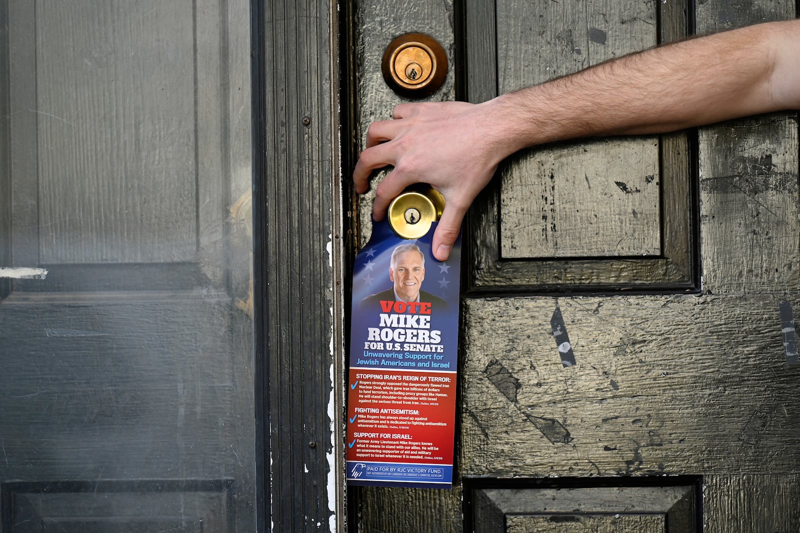 Republican Jewish Coalition member Noam Nedivi leaves a flyer promoting Republican Senate candidate former Rep. Mike Rogers, R-Mich., while canvassing a neighborhood, Sunday, Oct. 27, 2024, in West Bloomfield Township, Mich. (AP Photo/Jose Juarez)