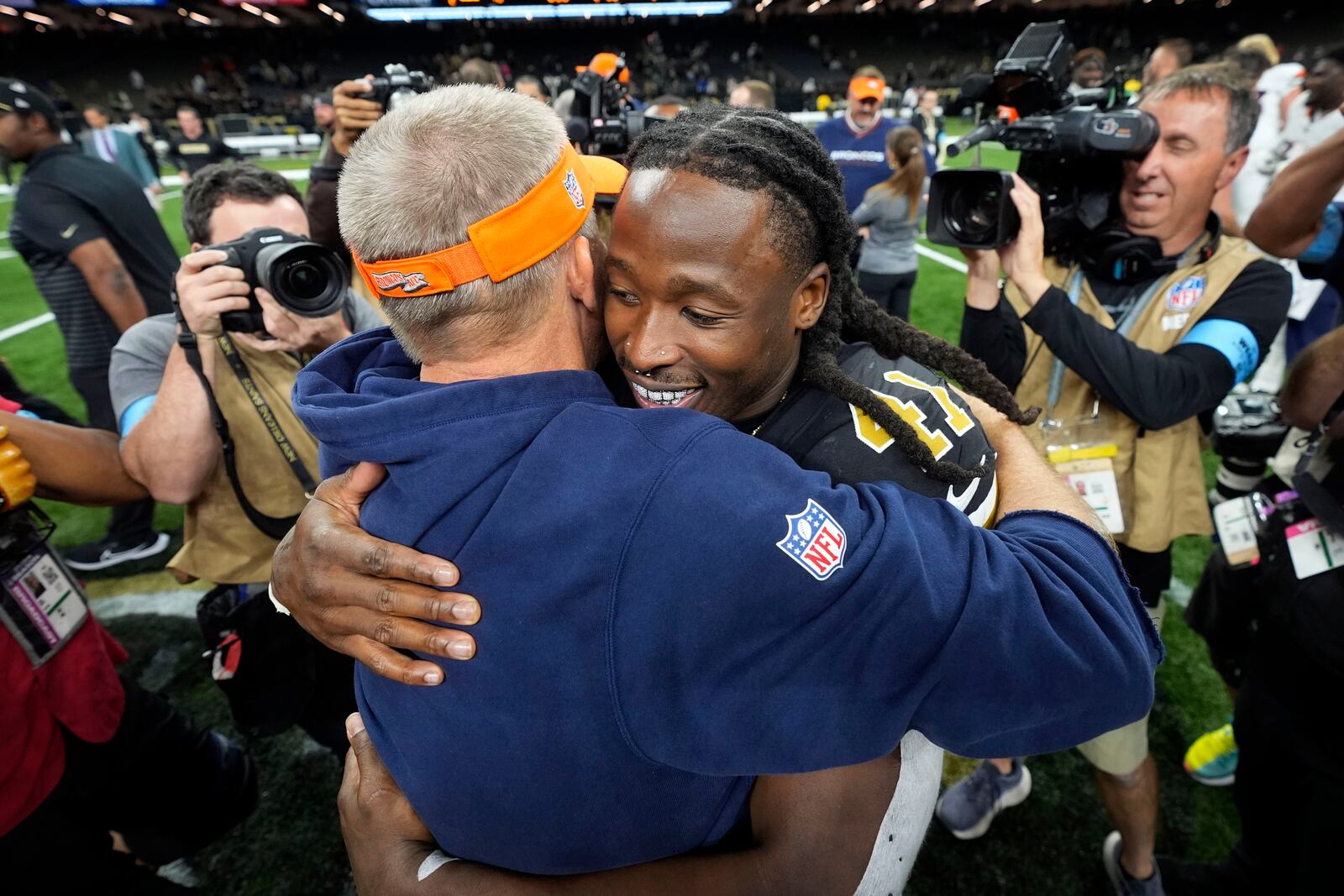 New Orleans Saints running back Alvin Kamara (41) hugs Denver Broncos head coach Sean Payton after an NFL football game, Thursday, Oct. 17, 2024, in New Orleans. The Broncos won 33-10. (AP Photo/Gerald Herbert)