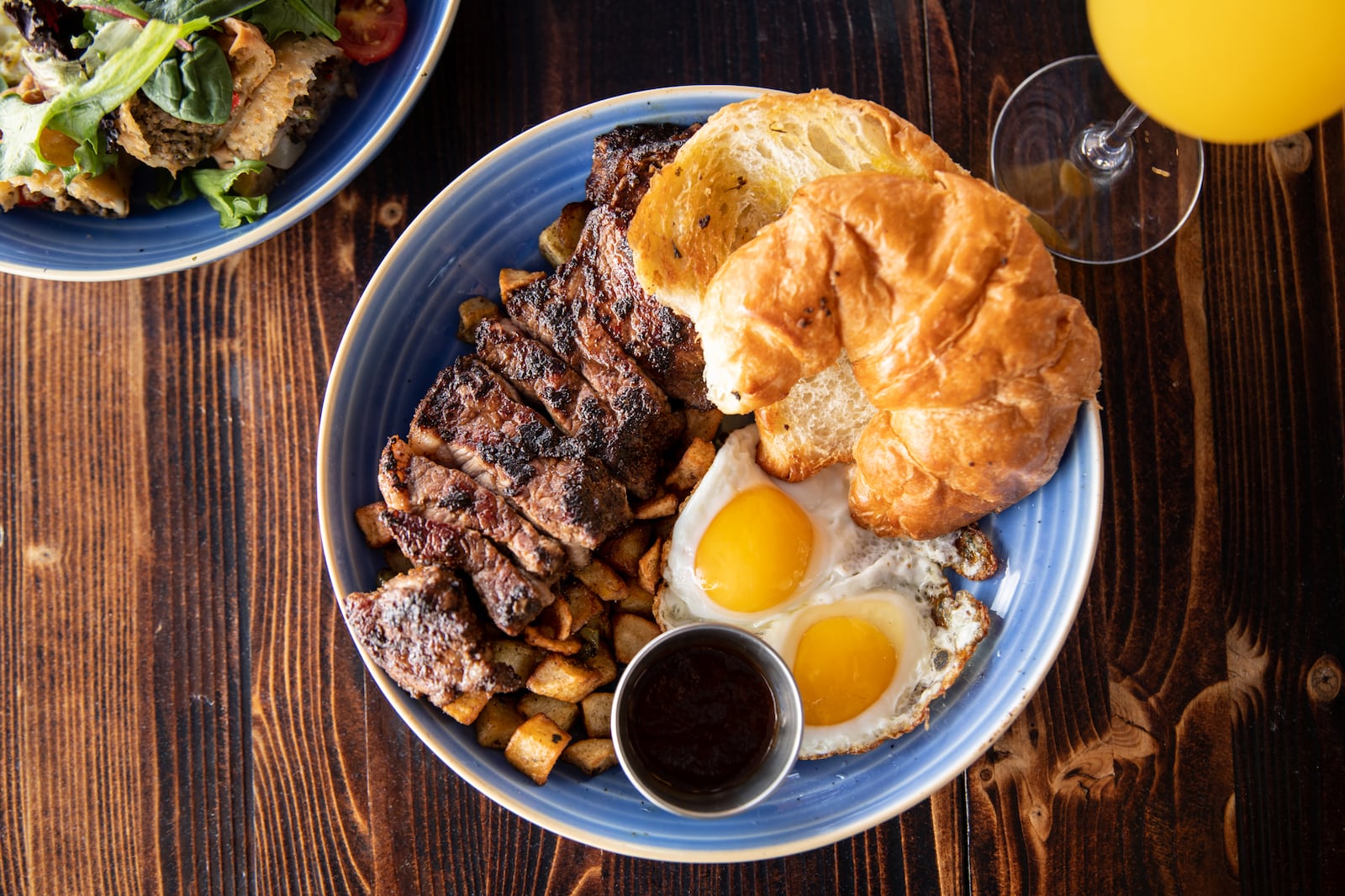 The Breakfast Boys' Coffee Rubbed Steak and Eggs with New York strip steak, eggs any style, breakfast potatoes, and a honey butter croissant. (Mia Yakel for The Atlanta Journal-Constitution)