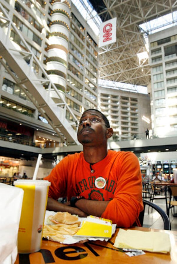 2:13 p.m. Atlanta: Georgia State University senior Darrell Davis, of Decatur, watches television coverage of the election as he eats his lunch in the atrium of the CNN Center Tuesday afternoon. Davis came to the CNN center to have lunch and to see what was happening with election coverage. Davis waited an hour this morning to vote. Davis plans to be up late tonight watching election coverage. Davis said, "It's exciting. I can't wait to see what happens."