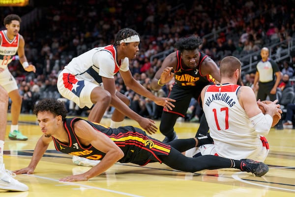 Atlanta Hawks forward Zaccharie Risacher, left, falls while trying to get a rebound against Washington Wizards center Jonas Valanciunas (17) during the first half of an Emirates NBA Cup basketball game, Friday, Nov. 15, 2024, in Atlanta. (AP Photo/Jason Allen)