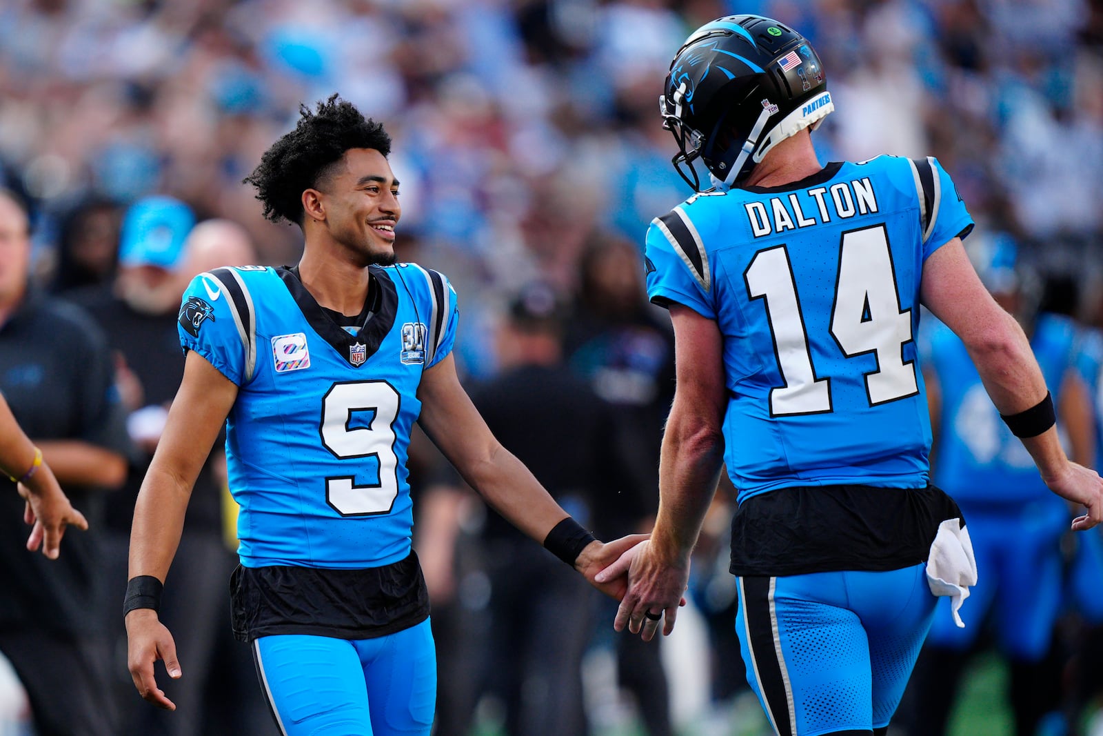 Carolina Panthers quarterback Bryce Young (9) congratulates Carolina Panthers quarterback Andy Dalton (14) after Dalton throws a touchdown pass in the first half of an NFL football game against the Atlanta Falcons n Charlotte, N.C., Sunday, Oct. 13, 2024. (AP Photo/Jacob Kupferman)