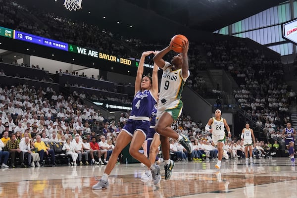 Baylor guard Aliyah Matharu (9) takes a shot as TCU's Donovyn Hunter (4) defends in the first half of an NCAA college basketball game in Waco, Texas, Sunday, March 2, 2025. (AP Photo/Tony Gutierrez)