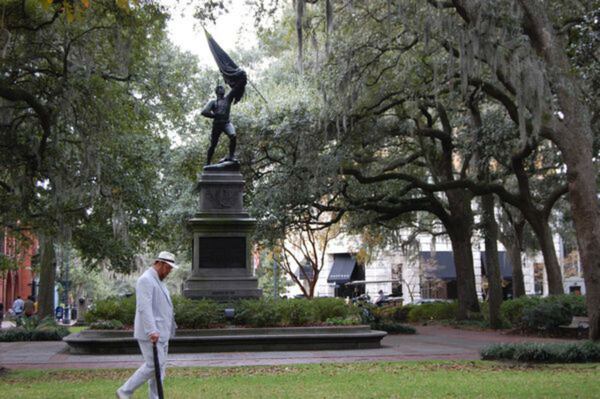 Dan Leger, aka “Savannah Dan,” sports a crisp seersucker suit and a bowtie as he leads a walking tour through Savannah's Madison Square. Under a new pilot program, tours in that square and others would be banned after 10 p.m.