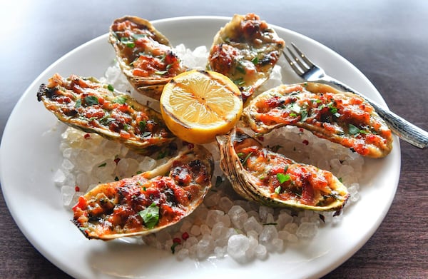 Baked Oysters, roasted garlic, spinach, fontina, bacon, grilled lemon. CONTRIBUTED BY CHRIS HUNT PHOTOGRAPHY