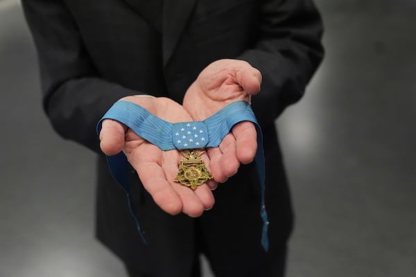 Jack Jacobs, a retired U.S. Army colonel who was awarded the Medal of Honor for his actions during the Vietnam War, poses for a photo holding the medal in his hands while being interviewed at the National Medal of Honor Museum in Arlington, Texas, Thursday, March 13, 2025. (AP Photo/Tony Gutierrez)