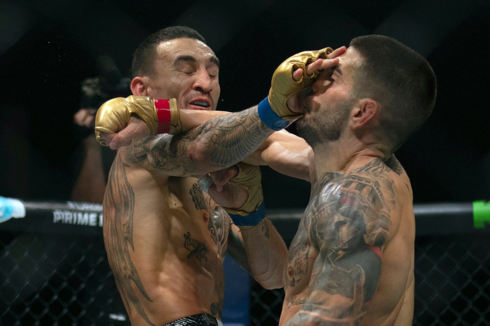 Champion Ilia Topuria, right, battles with Max Holloway during a mixed martial arts featherweight title bout at UFC Fight Night on Saturday, Oct. 26, 2024, in Abu Dhabi, United Arab Emirates. (AP Photo/Altaf Qadri)