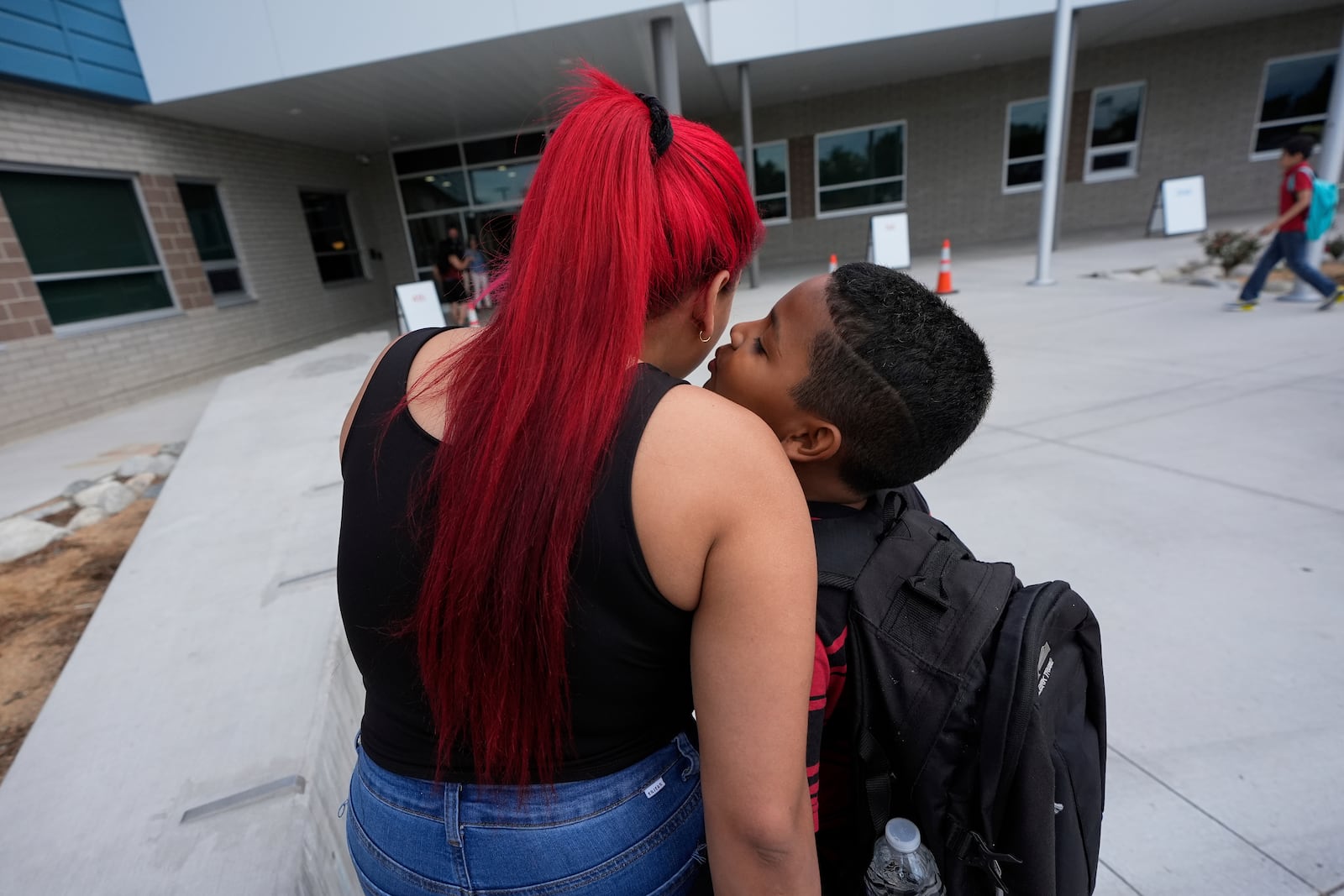 Dylan Martínez-Ramírez, right, kisses his mother goodbye while being dropped off at school Thursday, Aug. 29, 2024, in Aurora, Colo. (AP Photo/Godofredo A. Vásquez)