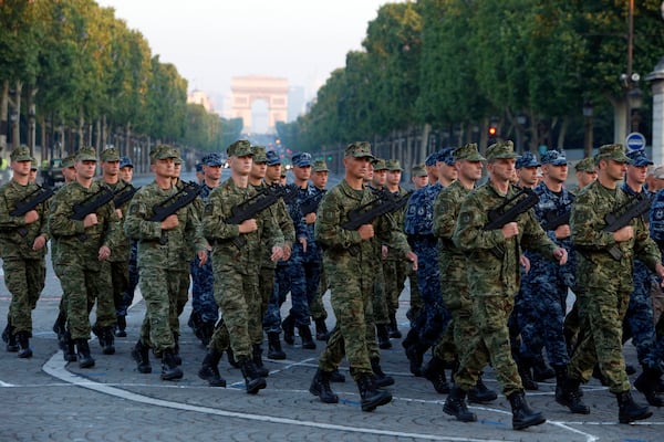 FILE - Army Forces of Croatia walk during the rehearsal of the French Bastille Day parade at the Champs-Elysees avenue in Paris, July 9, 2013. (AP Photo/Francois Mori, File)