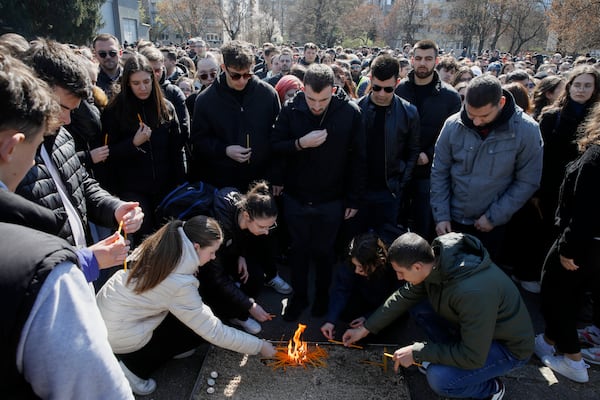 University students light candles for the victims of a massive nightclub fire in the town of Kocani, in Skopje, North Macedonia, Tuesday, March 18, 2025. (AP Photo/Boris Grdanoski)