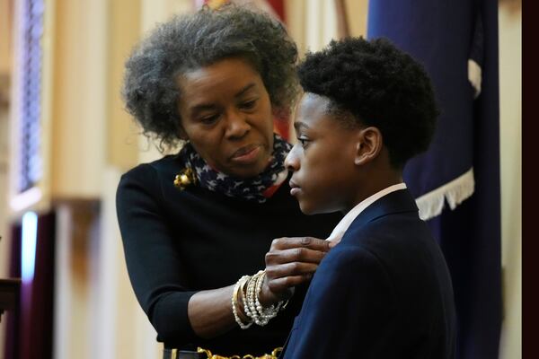 Virginia Lt. Gov. Winsome Earle-Sears, top left, adjusts the lapel of Senate Page Sylvester Powell, of Hampton Va., prior to the session of the Virginia General Assembly at the Capitol, Monday Jan. 13, 2025, in Richmond, Va. (AP Photo/Steve Helber)