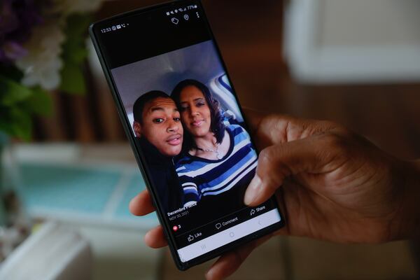 Decembre Pierce scrolls through photos of her son Parrish on her phone. He was killed in 2020 by a friend and fellow gang member.