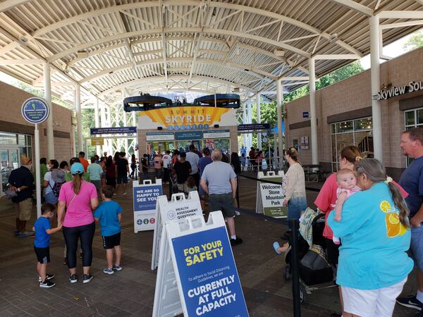 With new distancing rules set during the pandemic, families wait at a ticket area near the Summit Skyride at Stone Mountain Park on Labor Day weekend, Sunday, Sept. 6, 2020. MATT KEMPNER / AJC