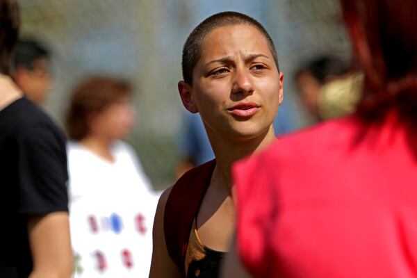 Emma Gonzalez, a senior who survived Wednesday's shooting at Marjory Stoneman Douglas High School, talks with people at North Community Park in Parkland, Fla., Sunday, Feb. 18, 2018. Gonzalez is one of the students who escaped the deadly school shooting and focused their anger Sunday at President Donald Trump, contending that his response to the attack has been needlessly divisive. (John McCall/South Florida Sun-Sentinel via AP)