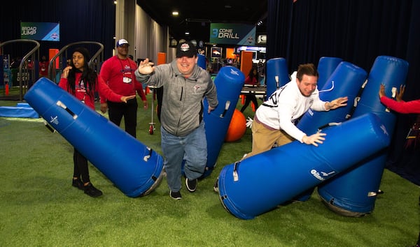 Brendan Schultz (left) and his brother Conner fight through tackling dummies during the Super Bowl Experience at the World Congress Center on Sunday, Jan. 27, 2019. (Photo:  STEVE SCHAEFER / SPECIAL TO THE AJC)