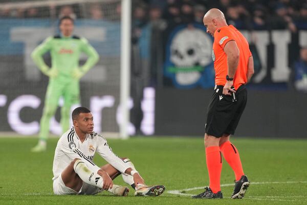 Real Madrid's Kylian Mbappe (left) speaks with referee Szymon Marciniak during the Champions League opening match between Atalanta and Real Madrid at Bergamo Stadium in Bergamo, Italy, on Tuesday, December 10, 2024. (AP Photo/Antonio Calanni)