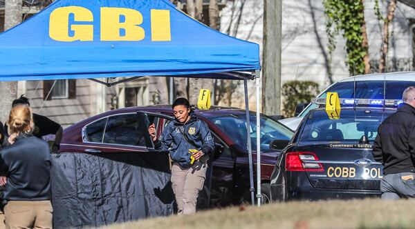 GBI agents  investigate an  officer-involved shooting that left a murder suspect dead near Powder Springs on Jan. 16.