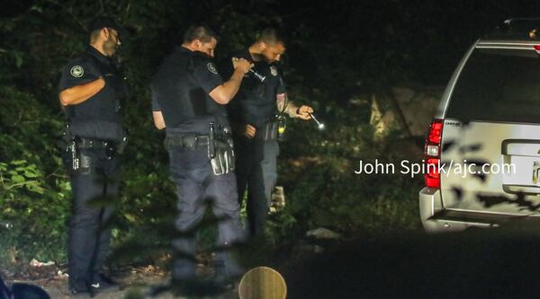 Atlanta police officers investigate Thursday morning after a body was found in an SUV parked near the rear gated entrance to South Bend Park in the Lakewood Heights neighborhood. 