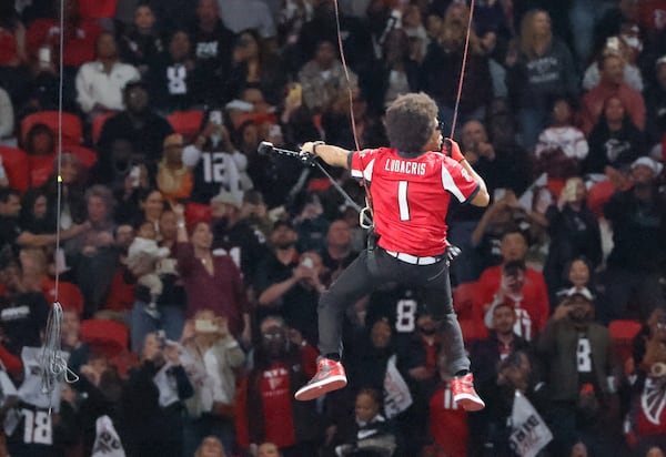 Ludacris descends from the top of the stadium while performing during the game.  The Atlanta Falcons celebrate Hip-Hop 50 with performances and appearances during their NFL football game between the Atlanta Falcons and the New Orleans Saints in Atlanta on Sunday, Nov. 26, 2023.   (Bob Andres for the Atlanta Journal Constitution)