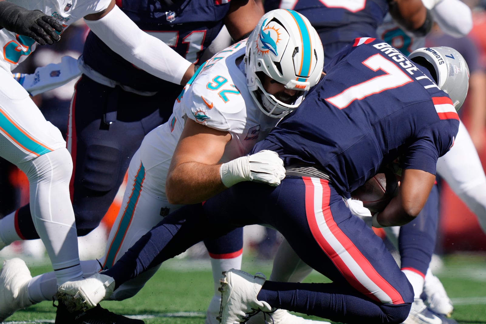 Miami Dolphins defensive tackle Zach Sieler (92) brings down New England Patriots quarterback Jacoby Brissett (7) during the first half of an NFL football game, Sunday, Oct. 6, 2024, in Foxborough, Mass. (AP Photo/Steven Senne)