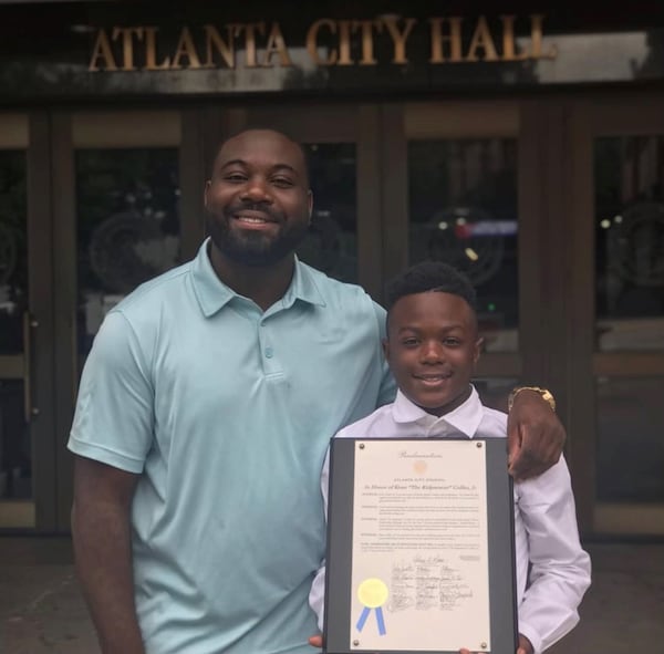 Kenneth Collier Jr. (right) receives a proclamation from the City of Atlanta in 2019. He wrote an anti-bullying book in the wake of his mother's shooting death.