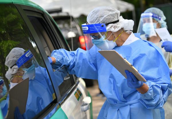 In this file photo, a medical professional collects a nasal swab from a potential COVID-19 patient at a drive-through COVID-19 testing site at Good News Clinic in Gainesville. (Hyosub Shin / Hyosub.Shin@ajc.com)