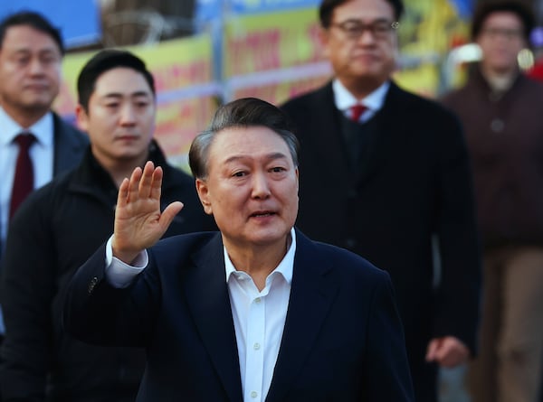 Impeached South Korean President Yoon Suk Yeol waves to his supporters as he comes out of a detention center in Uiwang, South Korea, Saturday, March 8, 2025. (Kim Do-hun/Yonhap via AP)