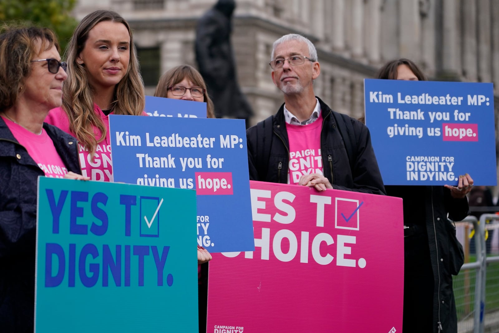 A small demonstration by people advocating assisted dying hold a protest outside the Hoses of Parliament as a bill to legalise assisted dying is to be put before lawmakers in London, England, Wednesday, Oct. 16, 2024. (AP Photo/Alberto Pezzali)