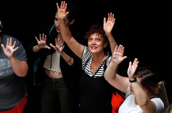 Actress Susan Sarandon, center, holds ups her hands as she and other protesters prepare to be arrested in the Hart Senate Office Building while protesting the separation of immigrant families, Thursday, June 28, 2018, on Capitol Hill in Washington.