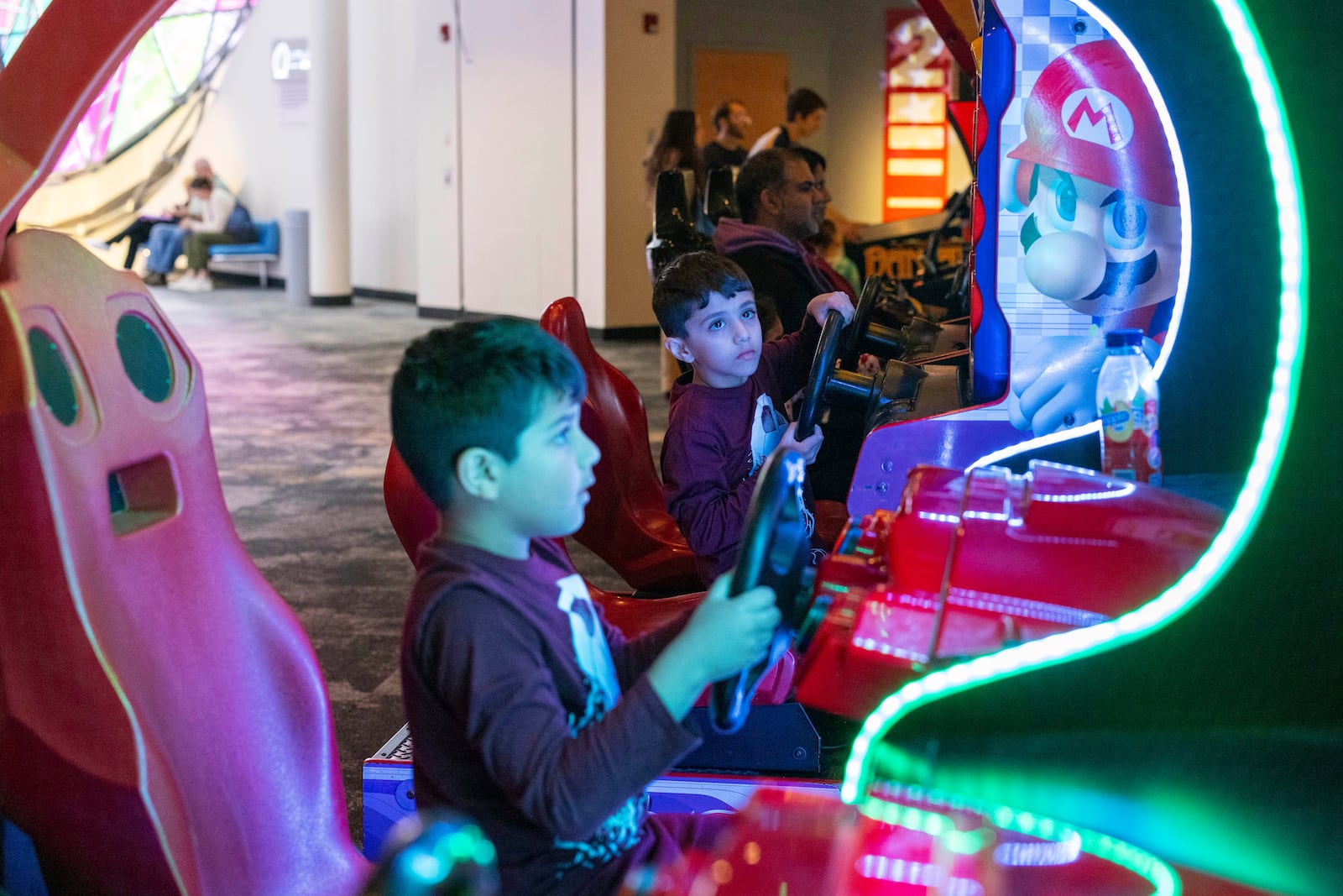 Twins Josh and Zach Alli, 6, of Toronto play racing games at The Strong National Museum of Play, Tuesday, Oct. 15, 2024, in Rochester, N.Y. (AP Photo/Lauren Petracca)