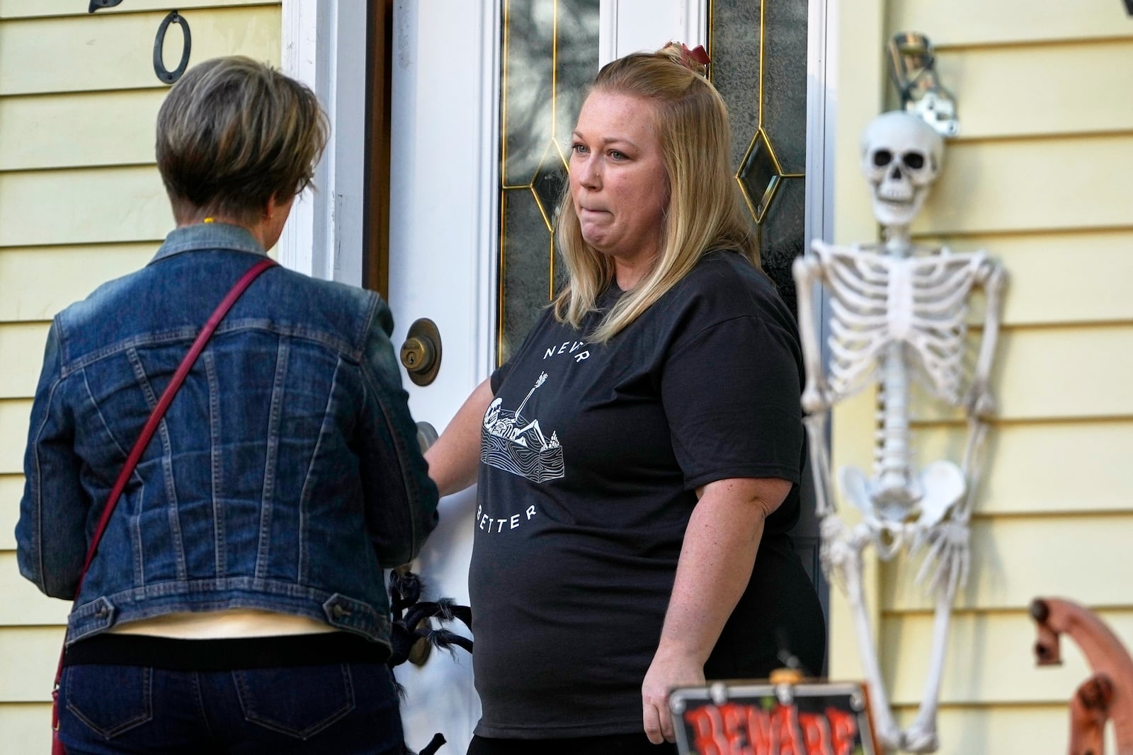 Kathy Moran, left, canvases houses Wednesday, Oct. 23, 2024, in Cross Plains, Wis. (AP Photo/Morry Gash)