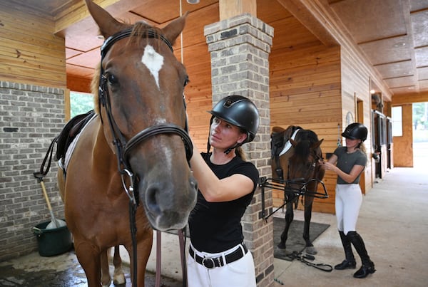 Maura Stringer (foreground) with Liam and her sister Nicole Stringer with Leo prepare before they ride at Hester’s horse farm home in Milton. (Hyosub Shin / Hyosub.Shin@ajc.com)