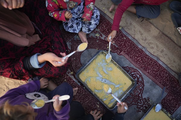 Yasmin Eid and her four daughters eat lentils at their tent in a refugee camp in Deir al-Balah, Gaza Strip, Tuesday, Nov. 19, 2024. (AP Photo/Abdel Kareem Hana)