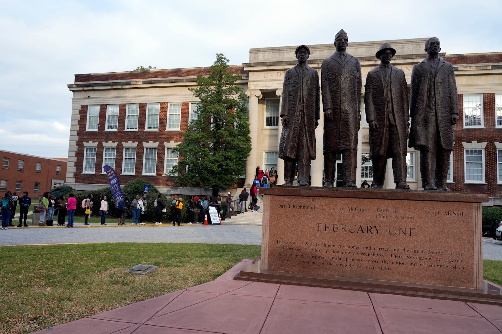 Students wait in line to vote in the shadow of a monument of the Greensboro Four protesters at the Dudley Building during a get out the vote rally at North Carolina A&T in Greensboro, N.C., Monday, Oct. 28, 2024. (AP Photo/Chuck Burton)