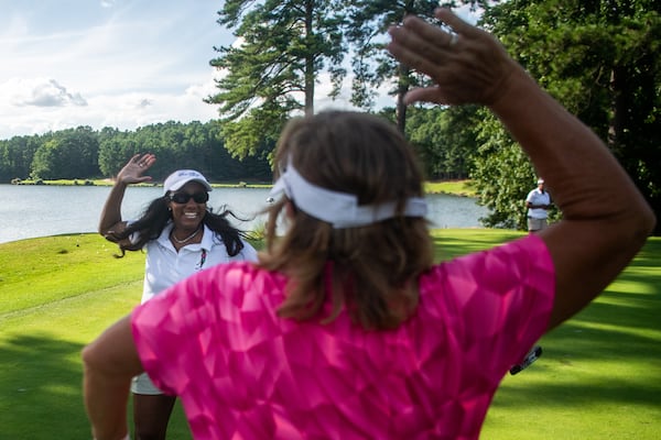 Bria Janelle, (left), CEO and founder of Her Shot high fives LPGA Golf Instructor Heidi Mitchell after scoring her ball in the hole during Her Shot golf program at Stone Mountain Golf Club in Stone Mountain on Monday, July 22, 2024.  (Ziyu Julian Zhu / AJC)