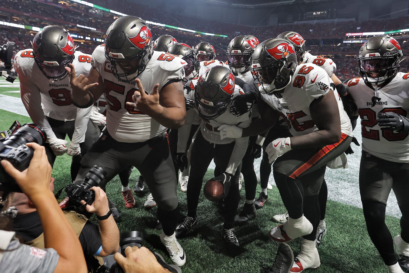 The Tampa Bay Buccaneers defense celebrates after linebacker Lavonte David, center, intercepted a pass by Atlanta Falcons quarterback Kirk Cousins during the second half of an NFL football game Thursday, Oct. 3, 2024, in Atlanta. (AP Photo/Butch Dill)