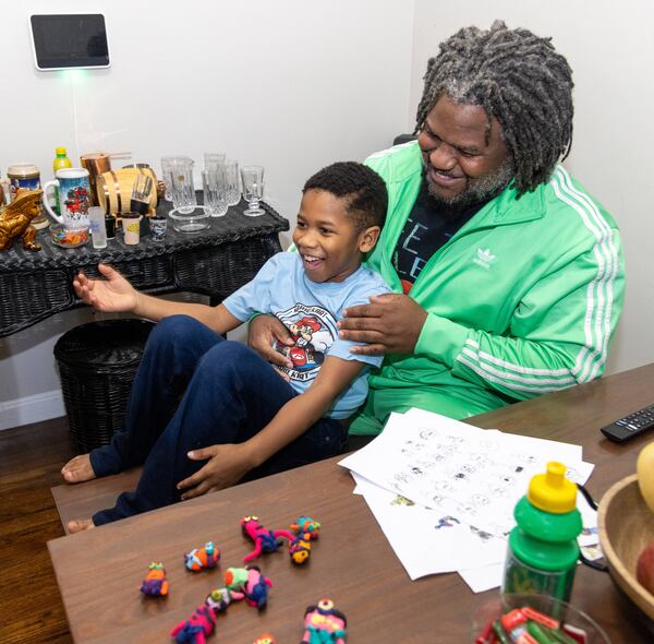 Michael Glenn (right) plays with his son MJ at his Decatur home. PHIL SKINNER FOR THE ATLANTA JOURNAL-CONSTITUTION
