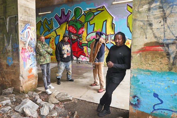 The United Kings, a graffiti crew, stand in front of their artwork on the Beltline’s West Trail under the Lee Street tunnel on Tuesday, Jan. 23, 2024. The members pictured are (from left) Marcus Wallace (KRAM), Dwayne Devoe (Just One), Fernando Alexander (ESKEME2) and Hackwin Devoe (ESKAN). (Jason Getz/AJC)